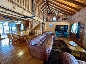 a living room with a leather couch and a table at Revilo Moose Ridge Mauston in Mauston