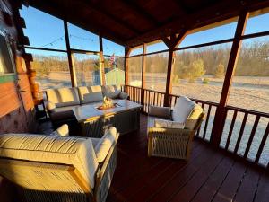 a screened in porch with couches and a table and chairs at Revilo Moose Ridge Mauston in Mauston