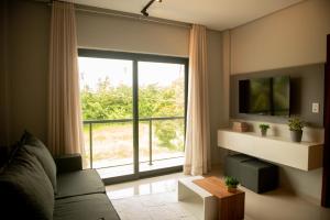 a living room with a large window and a couch at Apto com 2 Suites, Piscina e Jogos a 100m da praia in São Bento +33 photos