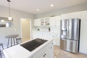 Una cocina con gabinetes blancos y un refrigerador de acero inoxidable. en River House, en Bend 32 fotos más