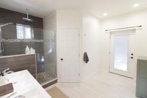 Un baño con lavabo y ducha y una puerta. en River House, en Bend