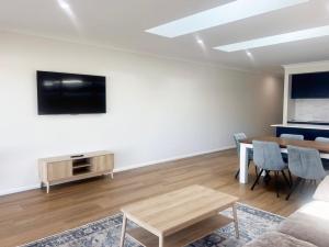 a living room with a table and a tv at Eliza's Escape 1 Wagga CBD in Wagga Wagga