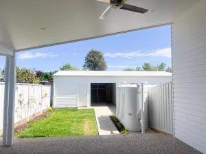 a white garage with a grass yard at Eliza's Escape 1 Wagga CBD in Wagga Wagga