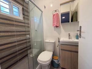 a bathroom with a toilet and a glass shower at Casa Nova com 3 quartos in São Gabriel +13 photos