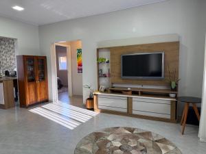 a living room with a flat screen tv on a wall at Casa Nova com 3 quartos in São Gabriel