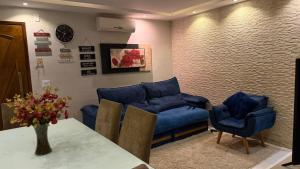 a living room with blue couches and a table and chairs at Marina Clube in São Pedro da Aldeia