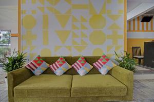 a couch with four pillows in a living room at Super Hotel O Home Elegant RK Fursungi in Pune