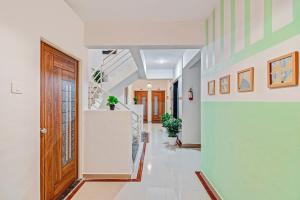 a hallway with a wooden door and a staircase at Super Hotel O Home Elegant RK Fursungi in Pune +38 photos