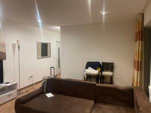 a living room with a brown couch and chairs at Schwavillage in Schwadorf