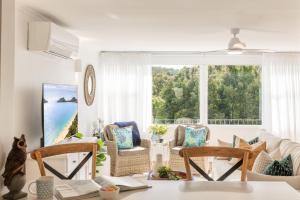 a living room with a view of the ocean at Shoal Bay 83 , 83 Horace St - Air Conditioned home away from home in Shoal Bay