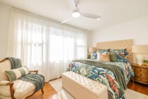 a bedroom with a bed and a chair and a window at Shoal Bay 83 , 83 Horace St - Air Conditioned home away from home in Shoal Bay
