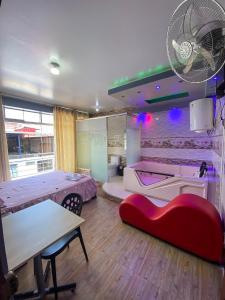 a room with two beds and a table with a red couch at Hotel Auka's in Aucayacu