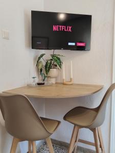 ヴェリアにある2BDR Downtown Veria Peach Blossomのテーブル(椅子2脚付)、壁掛けテレビ