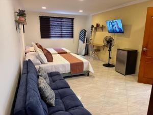 a bedroom with a bed and a couch in it at Kaobba Hostal in Medellín