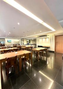 une salle à manger avec des tables et des chaises en bois dans l'établissement Davisis APT de Luxo, Piscina, Academia e Sauna, à Palmas