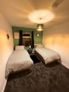two beds in a room with green walls at The Royal Hue 4bed house close to city centre in CBG