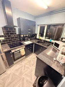 a kitchen with granite counter tops and a stove at The Royal Hue 4bed house close to city centre in CBG