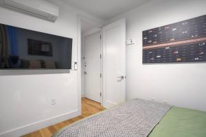 ニューヨークにあるComfortable 2BD Unit in Manhattanのベッドルーム1室(ベッド1台、壁掛けテレビ付) +2枚の写真