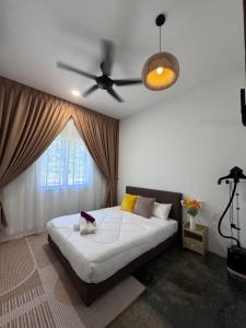 una camera con letto e ventilatore a soffitto di Rooma Bali Jeram a Kuala Selangor Altre 9 foto