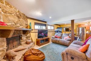 a living room with a stone fireplace and a tv at Peaceful Mountain Retreat with View, Near Boulder! in Boulder