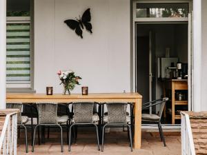 een tafel met stoelen en een vlinder aan de muur bij Hubertus I in Bad Pyrmont