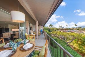 a balcony with a table and chairs and a view of the ocean at Eldorado K203 · EL K203 2BD Condo w AC Pool Beach Cabana in Kahana