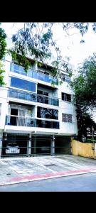 a tall white building with a fence in front of it at Quartos Privativos Com Cama de Casal in Vitória +44 photos