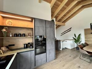 a kitchen with stainless steel appliances and wooden ceilings at Gipfelglück in Sankt Lambrecht