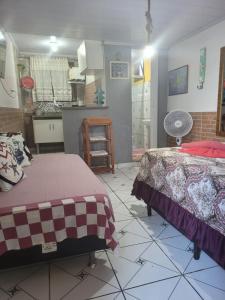 アングラ・ドス・レイスにあるCASA DA ILHA INN AND SPA Anexo2のベッド2台、キッチンが備わる広い客室です。