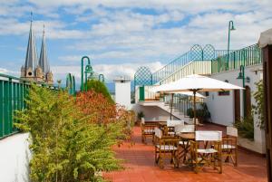 a patio with tables and umbrellas on a balcony at Provincial Plaza Hotel in Salta