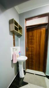 a bathroom with a sink and a wooden door at Pendeza homes in Naivasha