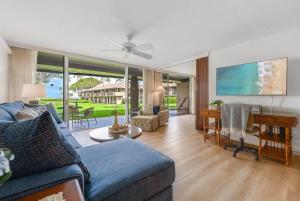a living room with a blue couch and a table at Eldorado H107 · EL H107 Updated Kaanapali Condo w Beach Cabana G in Kahana