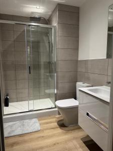 a bathroom with a shower and a toilet and a sink at Elegant 1 Bed Flat Near Stadium & Shops and free parking in Manchester