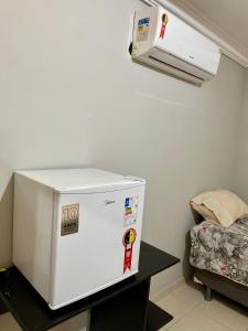 a white refrigerator sitting on a table in a room at Suite Cop Belém in Belém