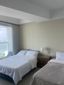 two beds in a hotel room with a window at Luxury Ocean View - Bocagrande in Cartagena de Indias