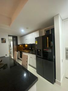 a large kitchen with black appliances and white cabinets at Luxury Ocean View - Bocagrande in Cartagena de Indias +14 photos