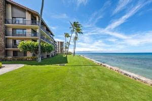 a view of the ocean from the lawn of a resort at Papakea B201 · PK B201 Updated Condo w Ocean View in Kahana