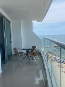 een balkon met een tafel en stoelen en het strand bij Luxury Ocean View - Bocagrande in Cartagena +14 foto's