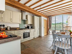 Una cocina con gabinetes blancos y una mesa y sillas. en 3 Bed in Malton 75898, en Amotherby