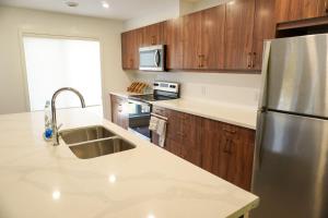 a kitchen with wooden cabinets and a stainless steel refrigerator at Entire 3 bedroom townhouse in Cambridge +15 photos