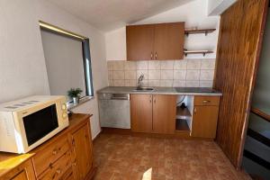 a kitchen with a microwave and a sink at Apartments by the sea Seline, Paklenica - 6528 in Seline +38 photos