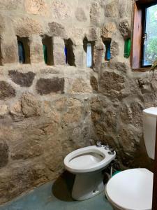 a stone bathroom with a toilet and a sink at El Jopi in Tanti