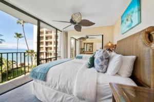 a bedroom with a bed and a balcony with the ocean at Valley Isle 401 · VI 401 Remodeled OceanFront Condo w Ocean View in Kahana +40 photos