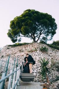 a man on a ledge looking at a rock wall at H.H.Le Palme in Amalfi
