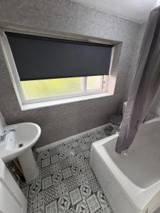 a bathroom with a sink and a toilet and a window at Cosy room 4 Gatwick in Crawley