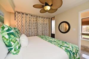 a bedroom with a white bed with a ceiling fan at Kahana Villa E601 · KV E601 Updated 1BD Condo w AC Pool Sunset V in Kahana +43 photos