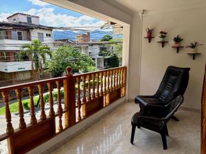 a balcony with a chair and a large window at Kaobba Hostal in Medellín