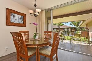 Un comedor con mesa y sillas y un balcón. en Eldorado J209 · EL J209 Spacious Studio w AC Pool and Beach Caba, en Kahana