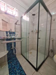 a bathroom with a glass shower and a sink at Suite Cop Belém in Belém