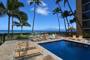 カハナにあるMahana 1008 · MA 1008 Luxury BeachFront Condoのラウンジチェアに座る人々とリゾートのプール